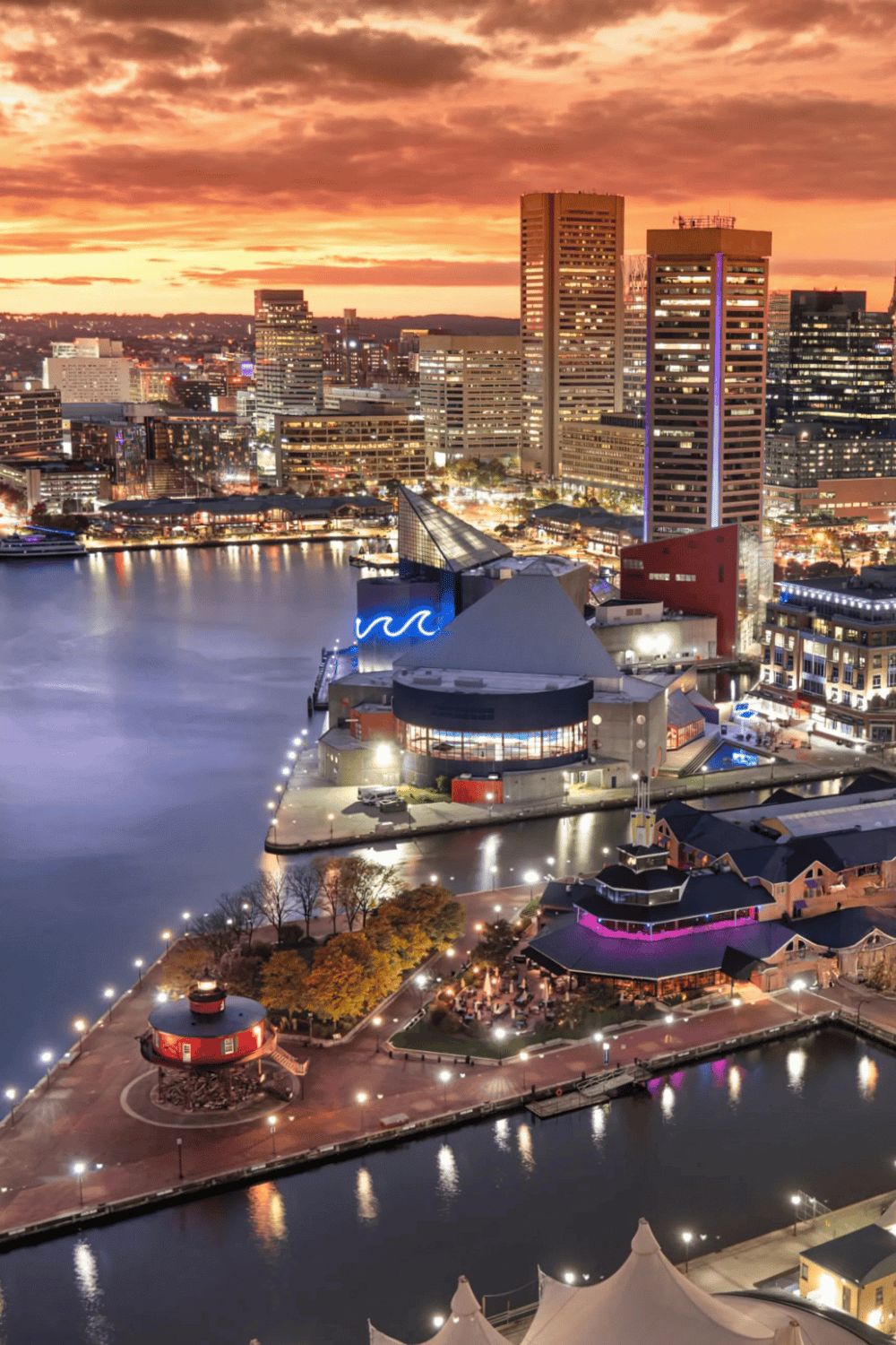 Vibrant city skyline at sunset with illuminated buildings and waterfront view in Baltimore, Maryland for QuestForDirections.