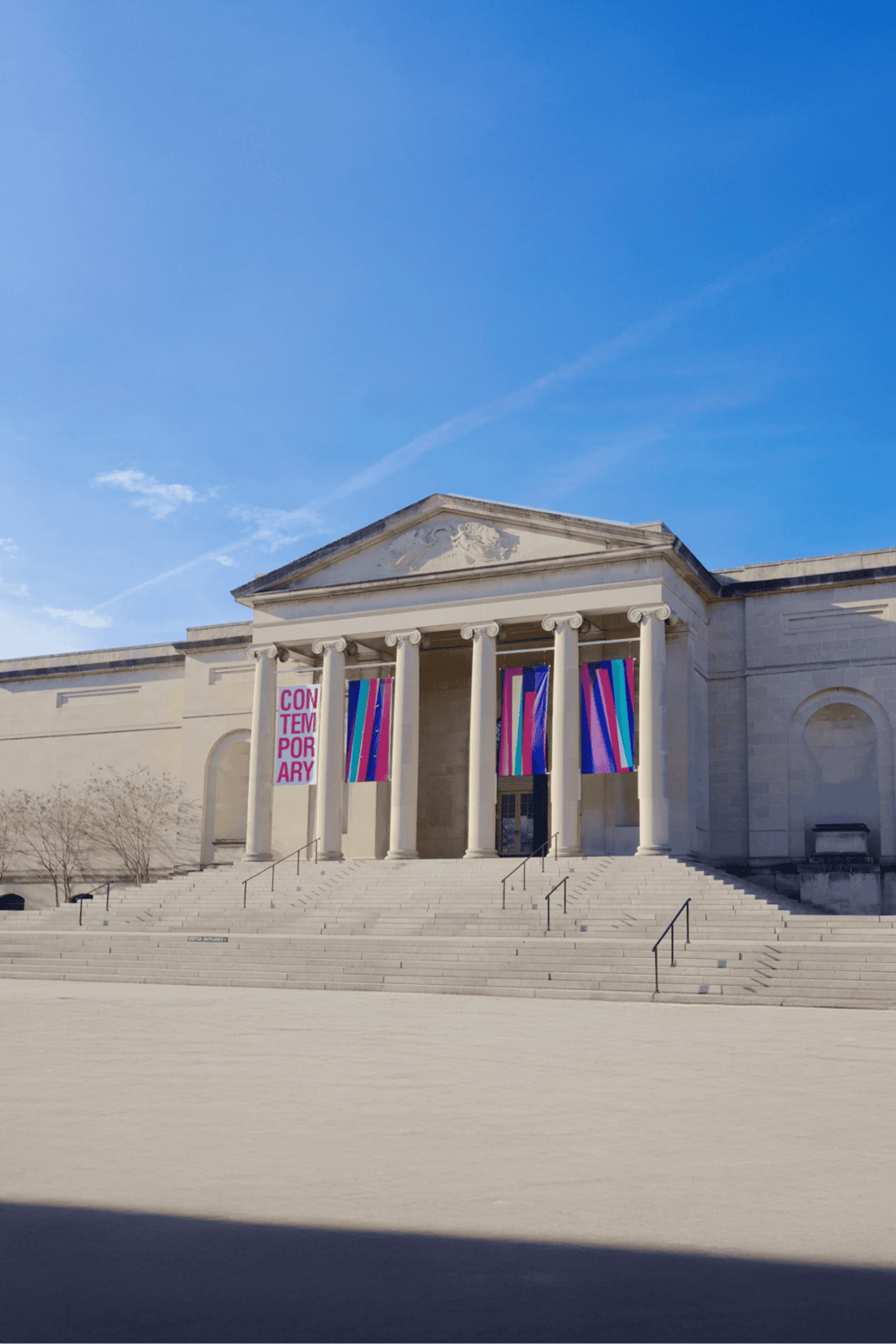 Modern art museum with grand steps and colorful banners, perfect for art and culture enthusiasts.