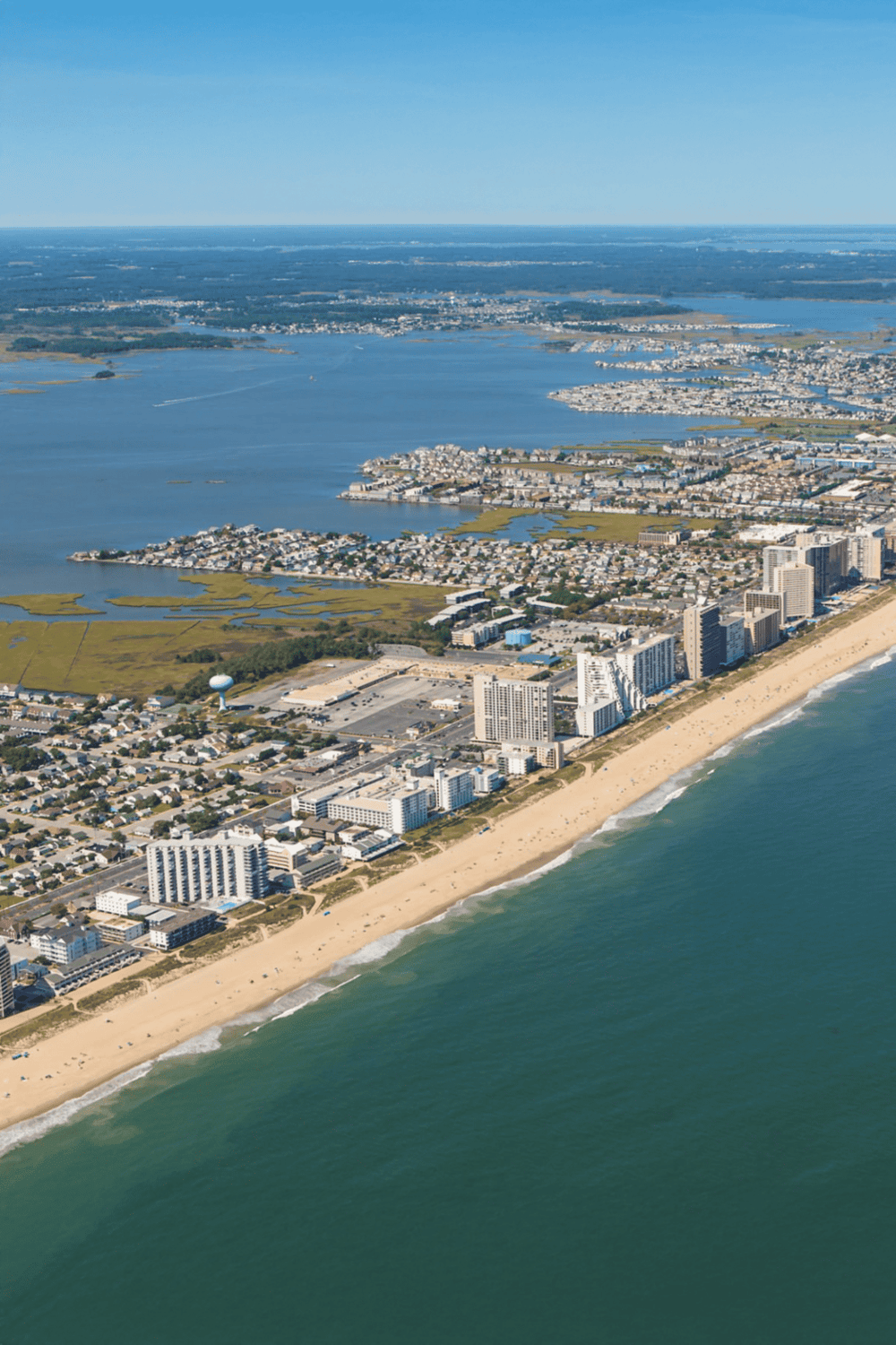 Aerial view of coastal cityscape with beaches, high-rise hotels, and waterways perfect for travel and tourism.