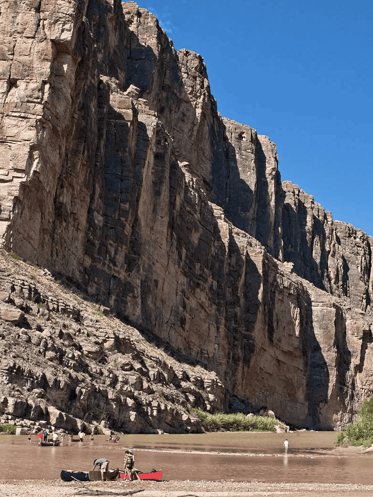 Stunning canyon landscape with towering cliffs and a river for outdoor adventure.