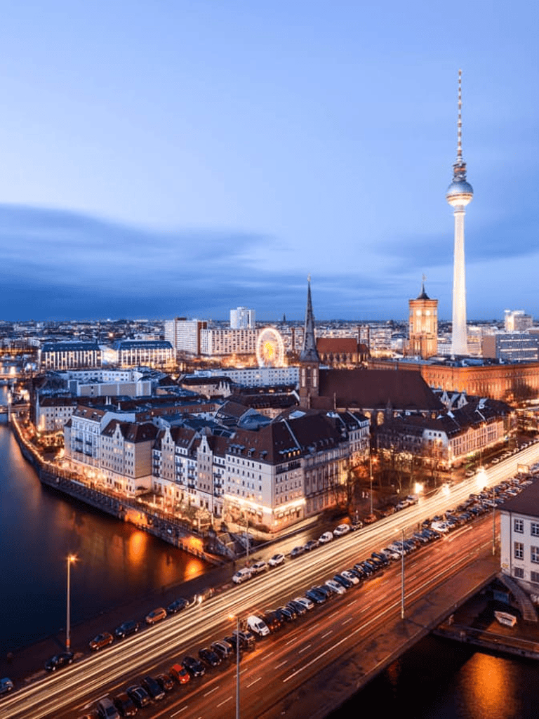 Bright Berlin cityscape featuring the TV Tower at dusk, showcasing urban skyline, city lights, and historic architecture.
