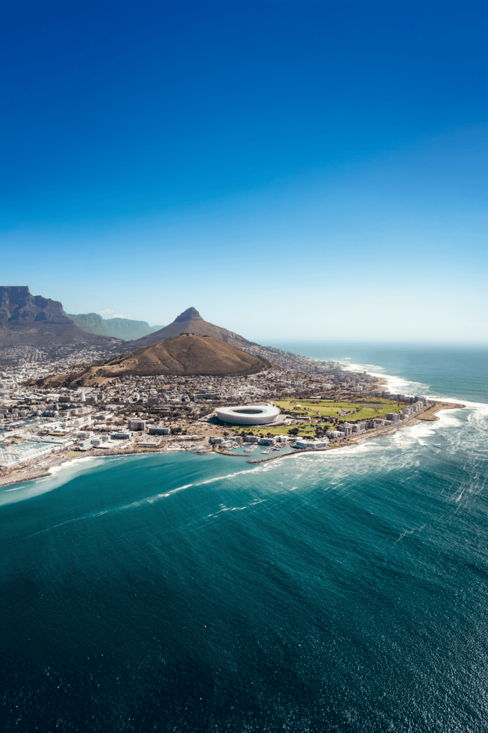 Modern aerial view of Cape Town, featuring Table Mountain and the V&A Waterfront, a top travel destination in South Africa.