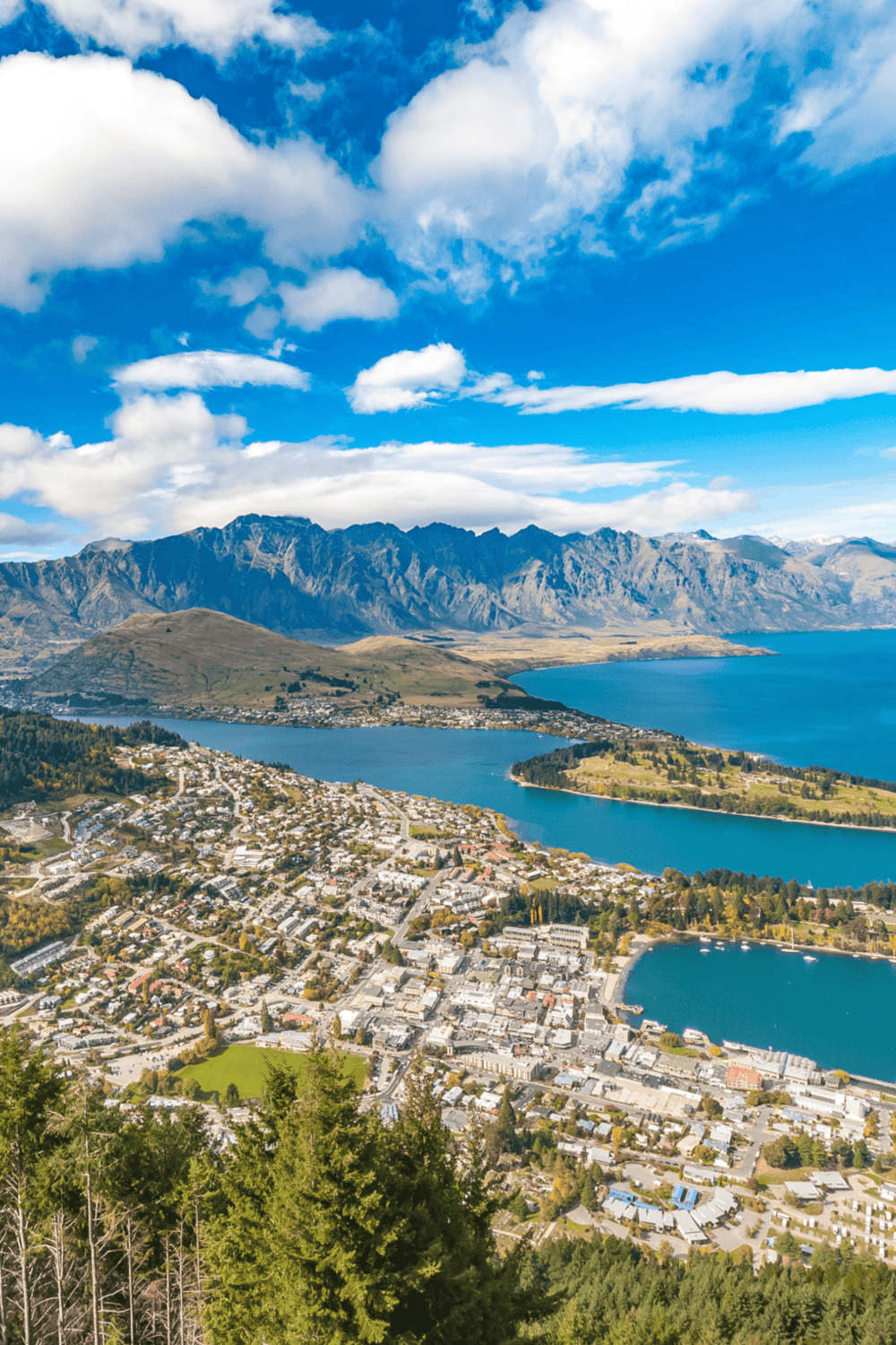 Aerial view of Queenstown New Zealand with lake, mountains, and townscape, perfect for travel directions.