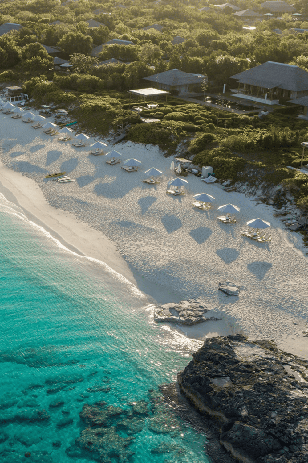 Relaxing beach with umbrellas and crystal-clear water, perfect for seaside vacations and coastal getaways.
