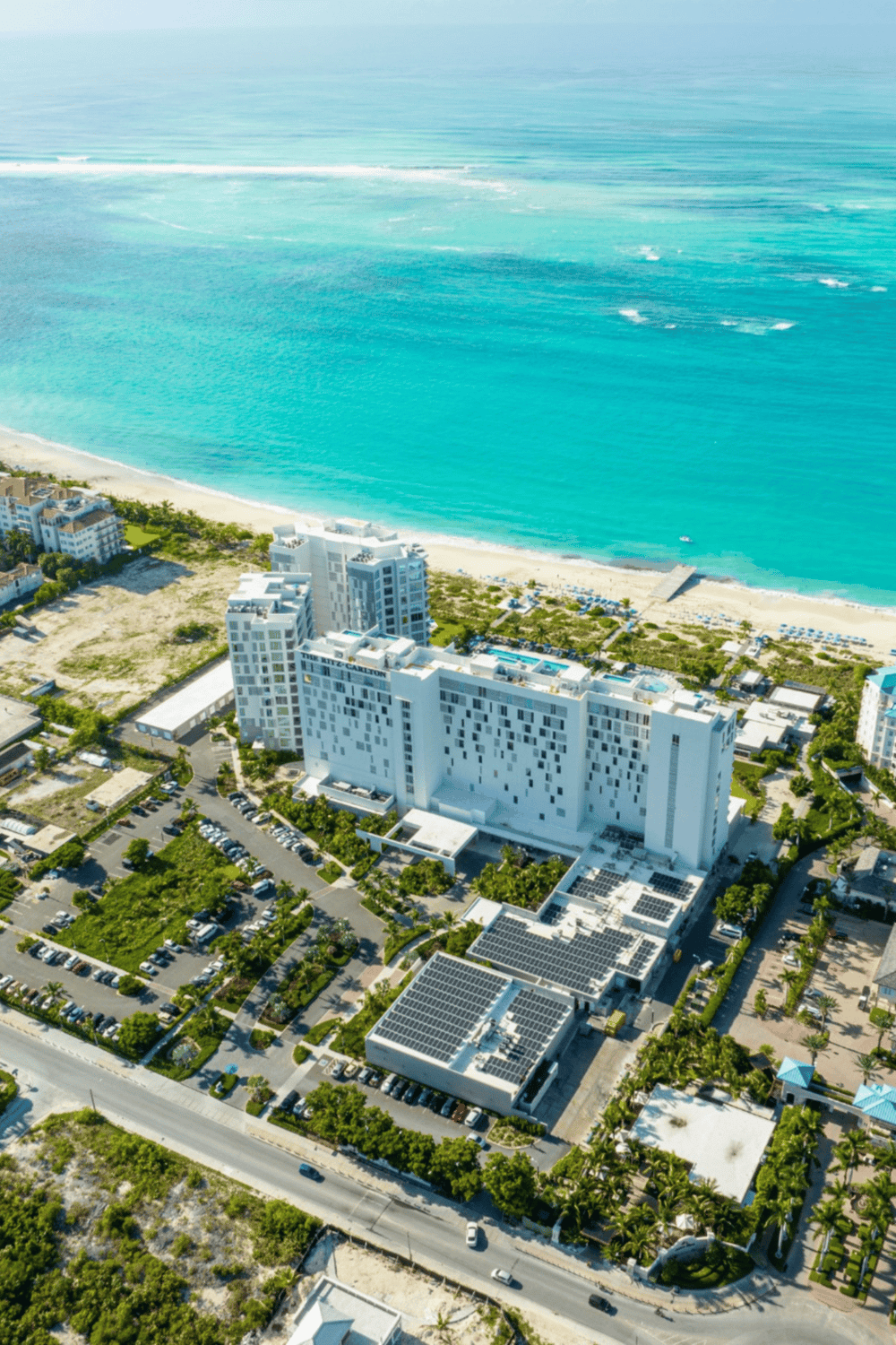 Modern beachfront hotel with ocean views and tropical landscaping.