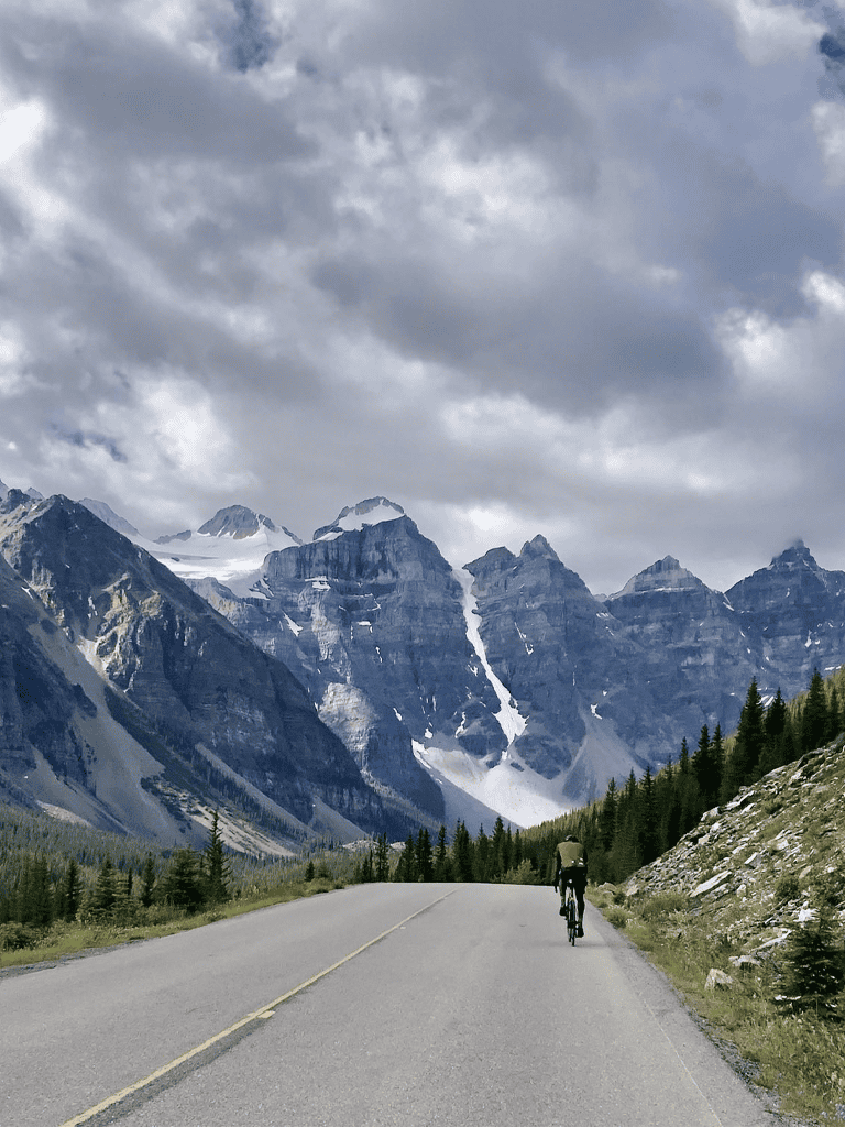 Breathtaking mountain landscape with cyclist on scenic highway in national park.