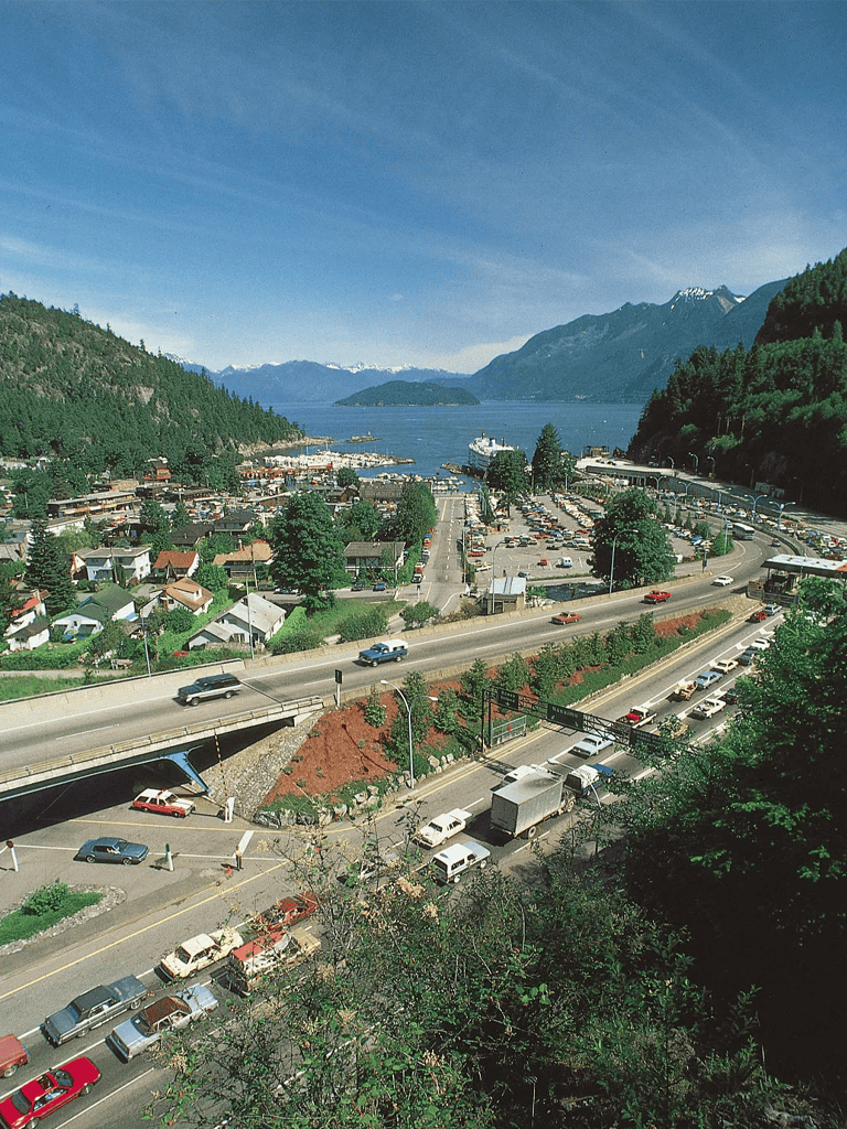 Scenic coastal town with mountains, harbor, and busy roads in Oregon.
