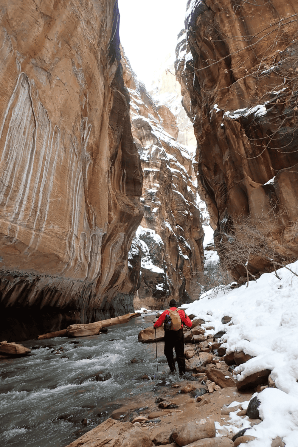 Canyon hiking through snow-covered cliffs, adventurous trail with rugged terrain and scenic views.