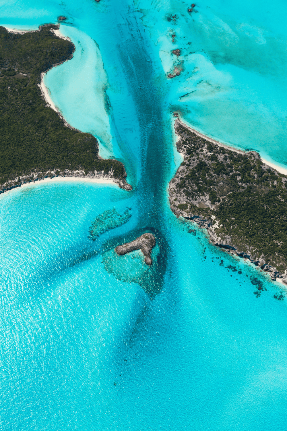 Vibrant aerial view of a tropical waterway with turquoise water and lush green islands.