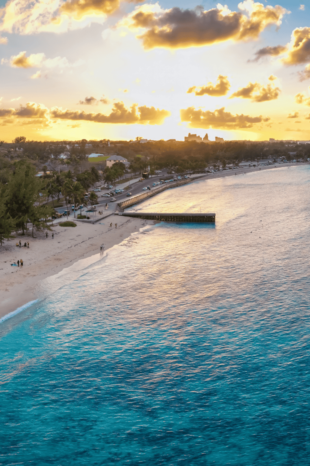Sunset over a beach with parking and city skyline, scenic coastal view for travel destinations and vacation Planning.