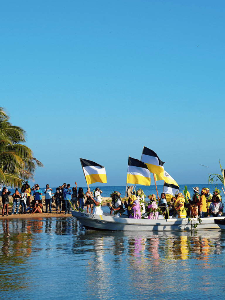 Colorful boat parade on a tropical beach celebrating local culture and traditions.