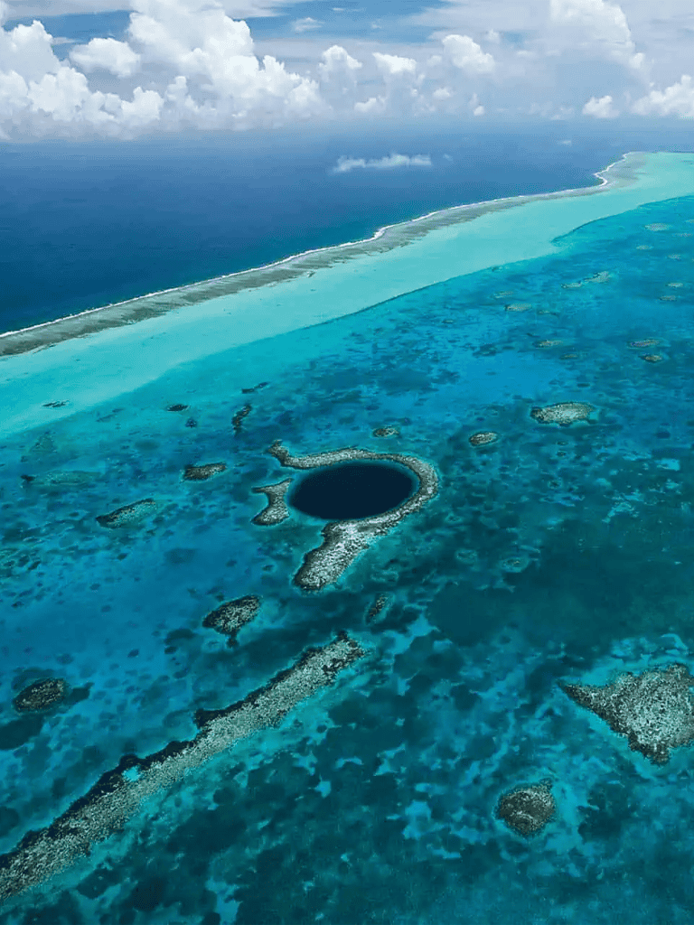 Vast coral reef and lagoon landscape with ocean in the background.