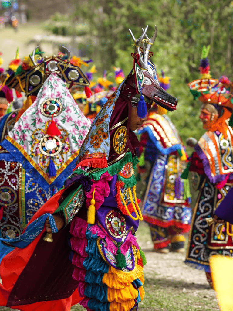 Vibrant traditional cultural attire at a festive outdoor event, showcasing colorful costumes and intricate accessories.
