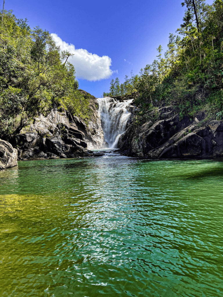 Serene waterfall surrounded by lush greenery at QuestForDirections scenic location.