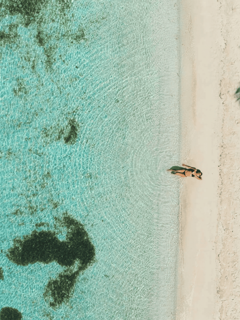 Serene tropical beach with clear turquoise water and white sandy shore, perfect for relaxation and vacation.