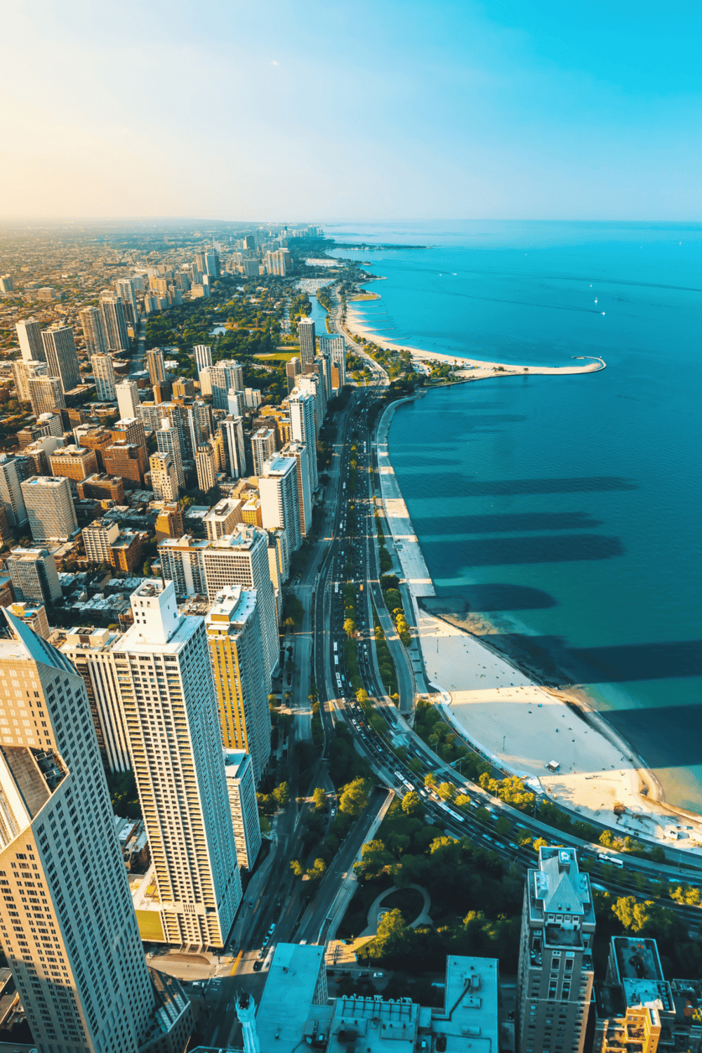 Vibrant city skyline along Lake Michigan with high-rise buildings and beach, highlighting urban travel destinations.