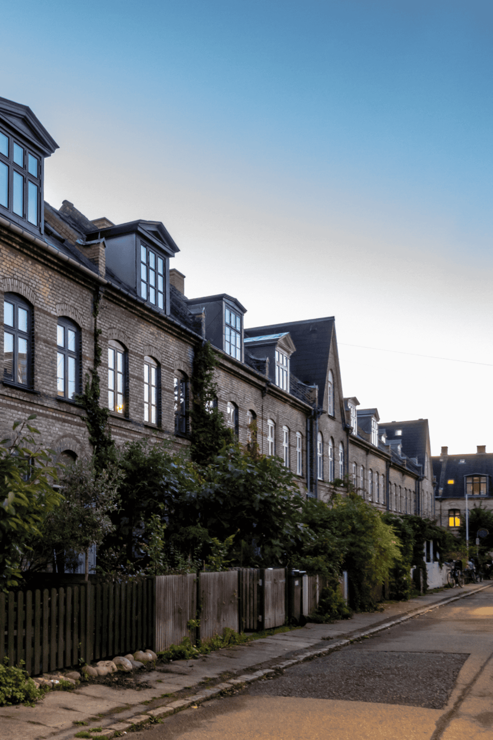 1. Victorian-style brick townhouses with dormer windows and greenery.
