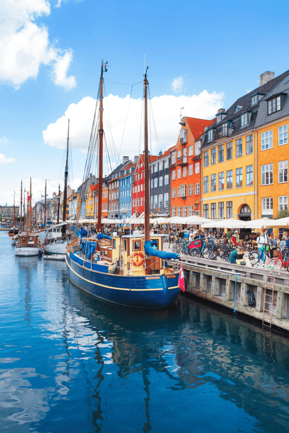 Colorful Danish waterfront with boats and vibrant buildings in Copenhagen.