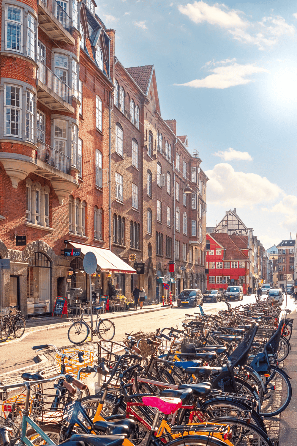 Colorful European city street with bicycles, historic architecture, and sunny sky.