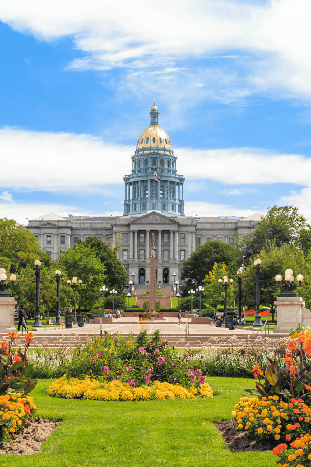 Historic Colorado State Capitol with lush gardens and vibrant flowers in Denver, Colorado.