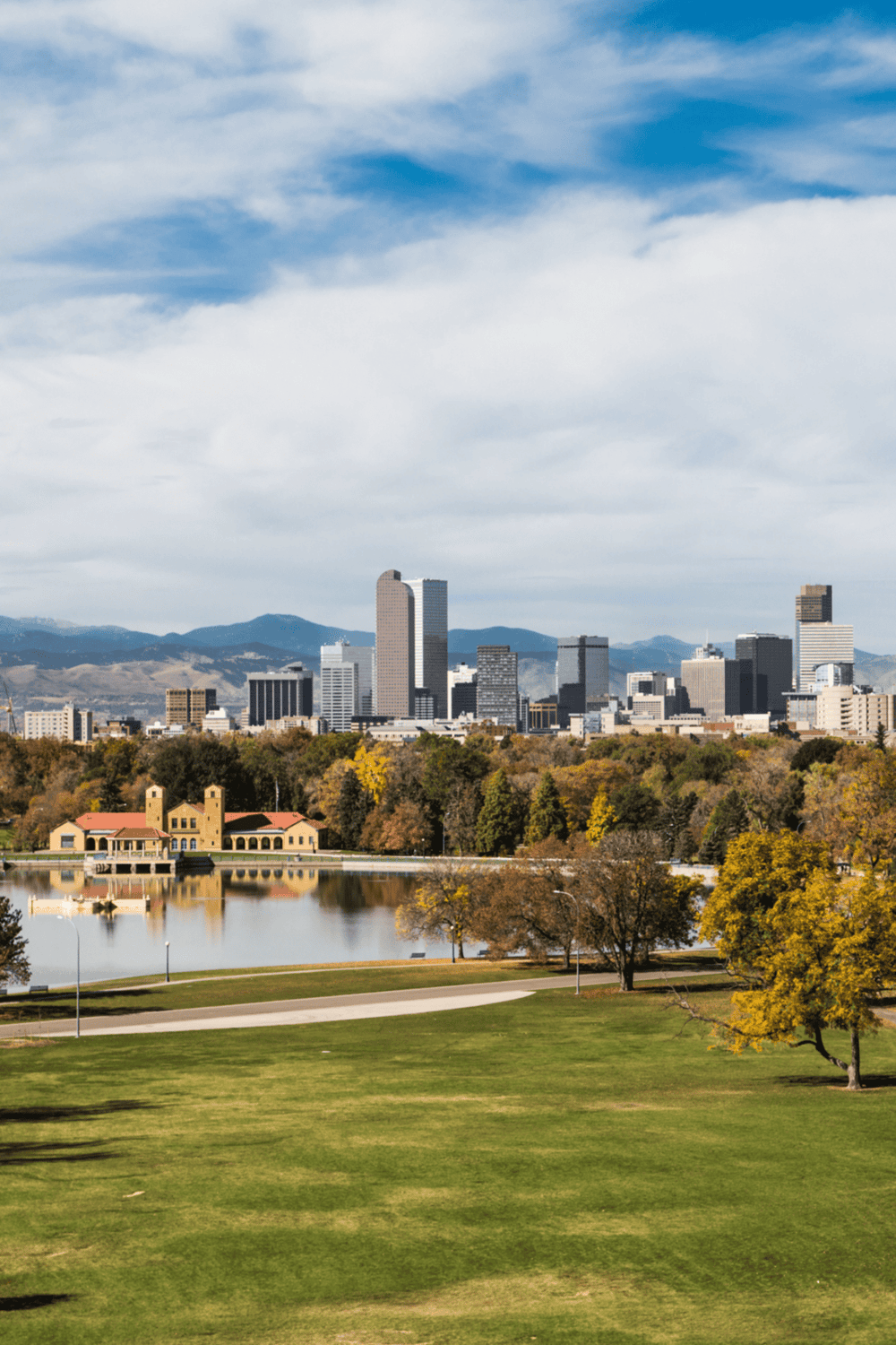 Vibrant downtown skyline with skyscrapers, lush green park, and water fountain, scenic cityscape view.