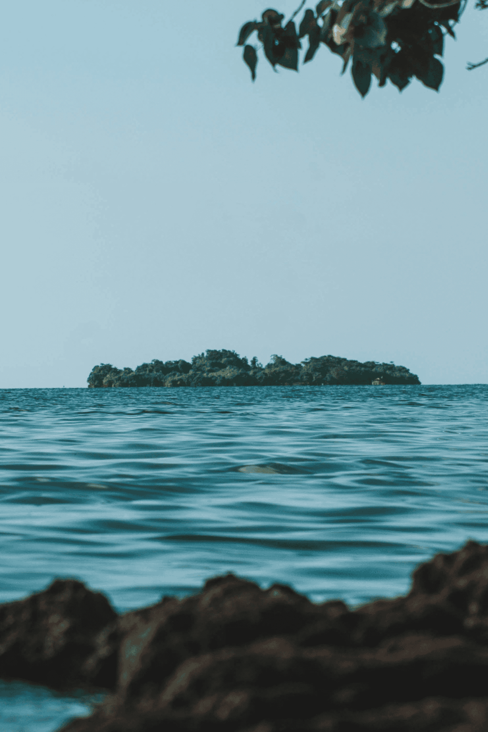 Secluded island with lush greenery and calm ocean waters, perfect for exploration and adventure.