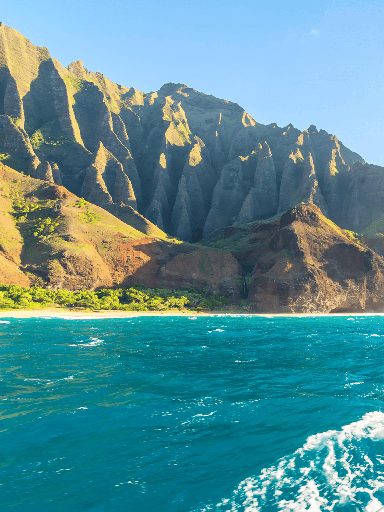 Spectacular coastal mountain scenery with lush greenery and vibrant ocean waters.