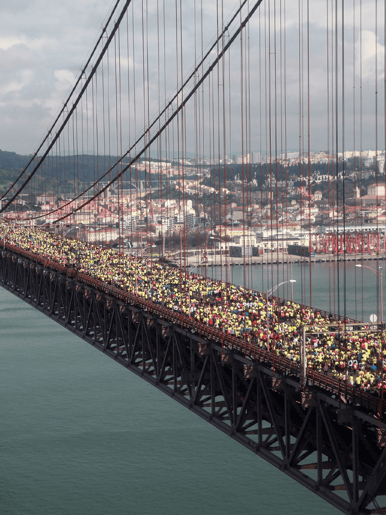 Crowd crossing Golden Gate Bridge during a public event or walk, showcasing San Francisco skyline in background.