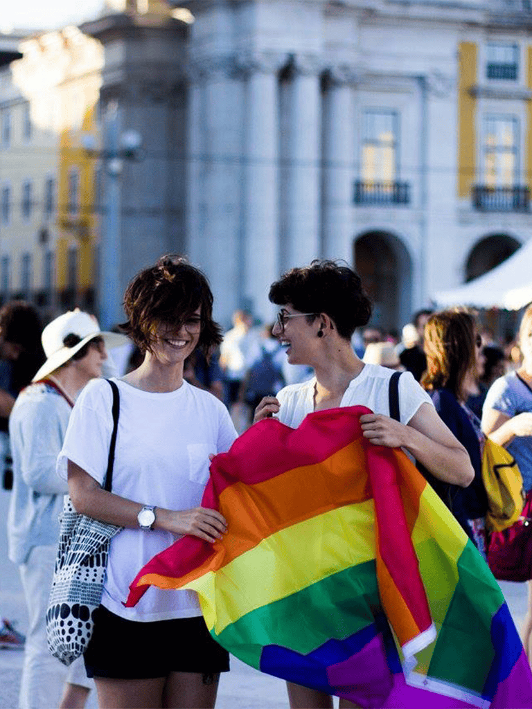 Rainbow pride flag in LGBT pride parade celebration, diverse people enjoying equality and inclusion.