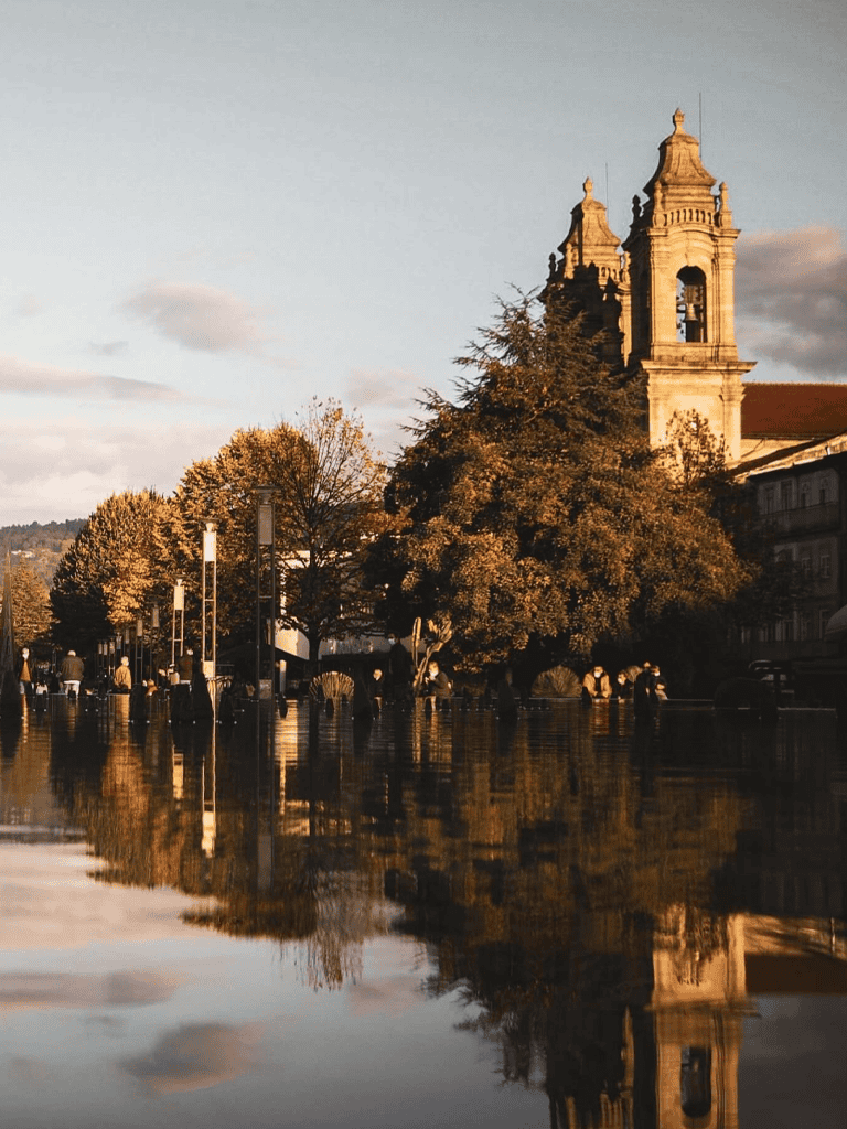 Stunning cityscape with historic church and reflections on water during golden hour.