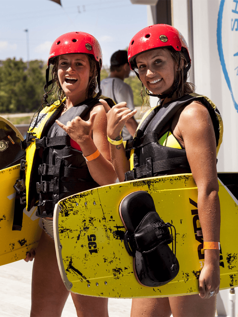 Adventurous women in water sports gear ready for wakeboarding or water adventure at Quest for Directions.