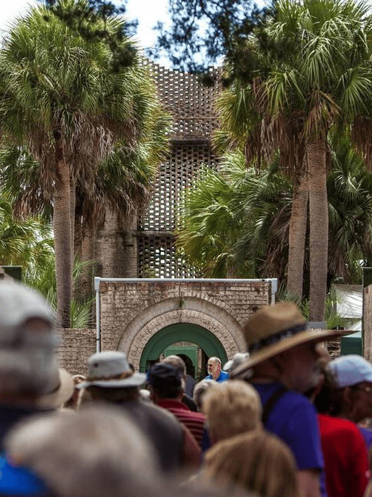 Palm trees at Quest for Directions cultural site with tour group in the background.