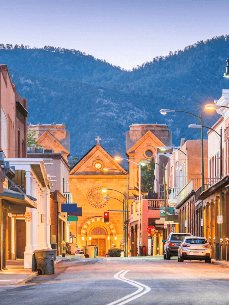 Charming mountain town street with historic church, colorful buildings, and scenic mountain backdrop.