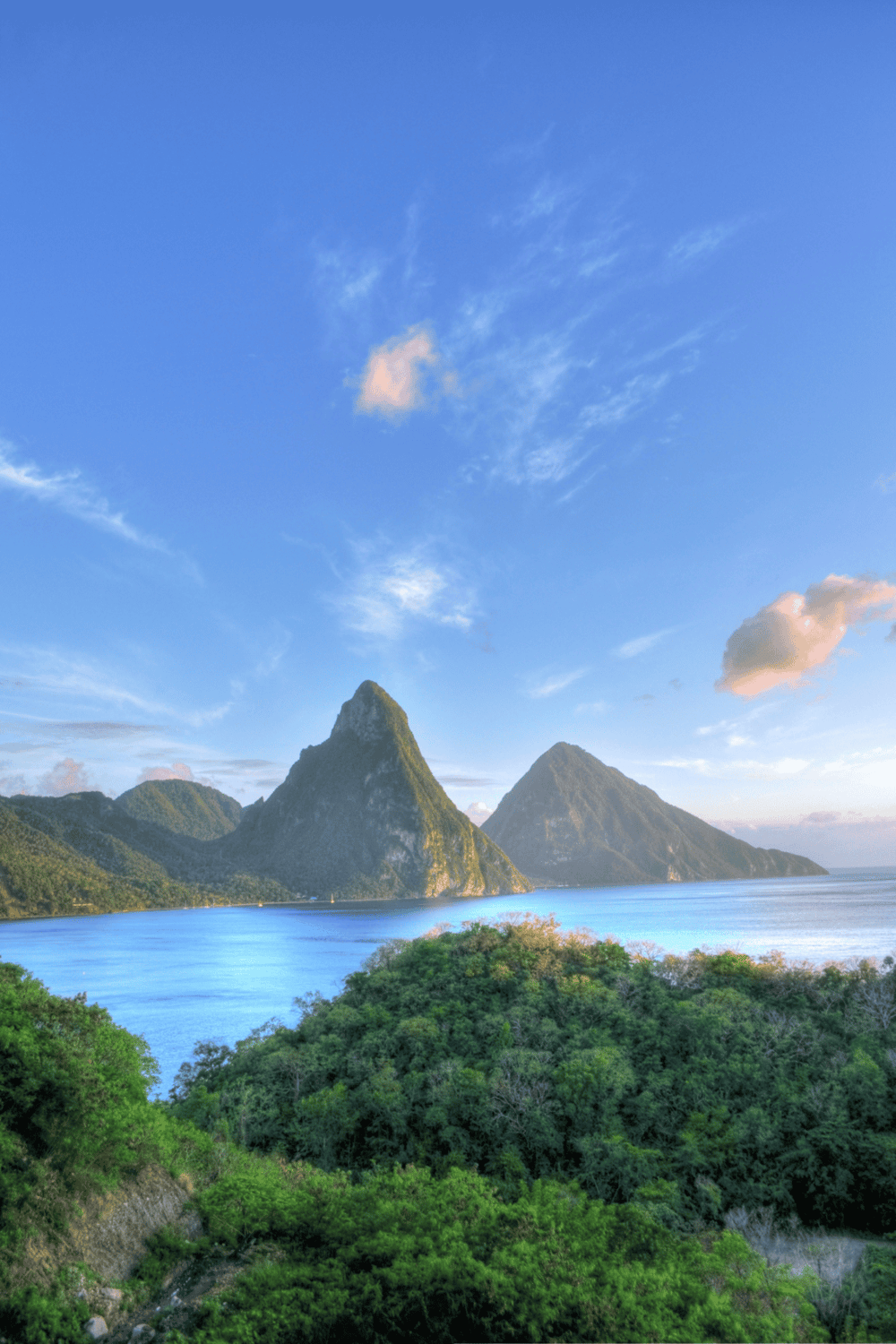 Majestic mountain landscape with lush greenery, blue sky, and calm water, showcasing scenic outdoor adventure and travel destinations.