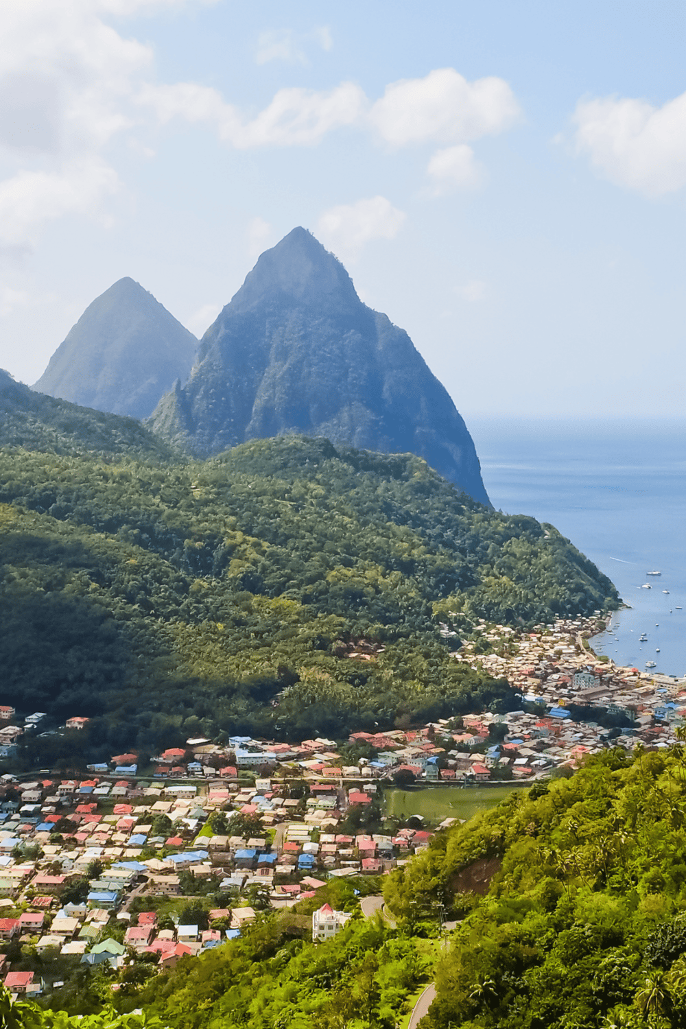 Lush mountain landscape with a coastal village, highlighting travel and adventure destinations.