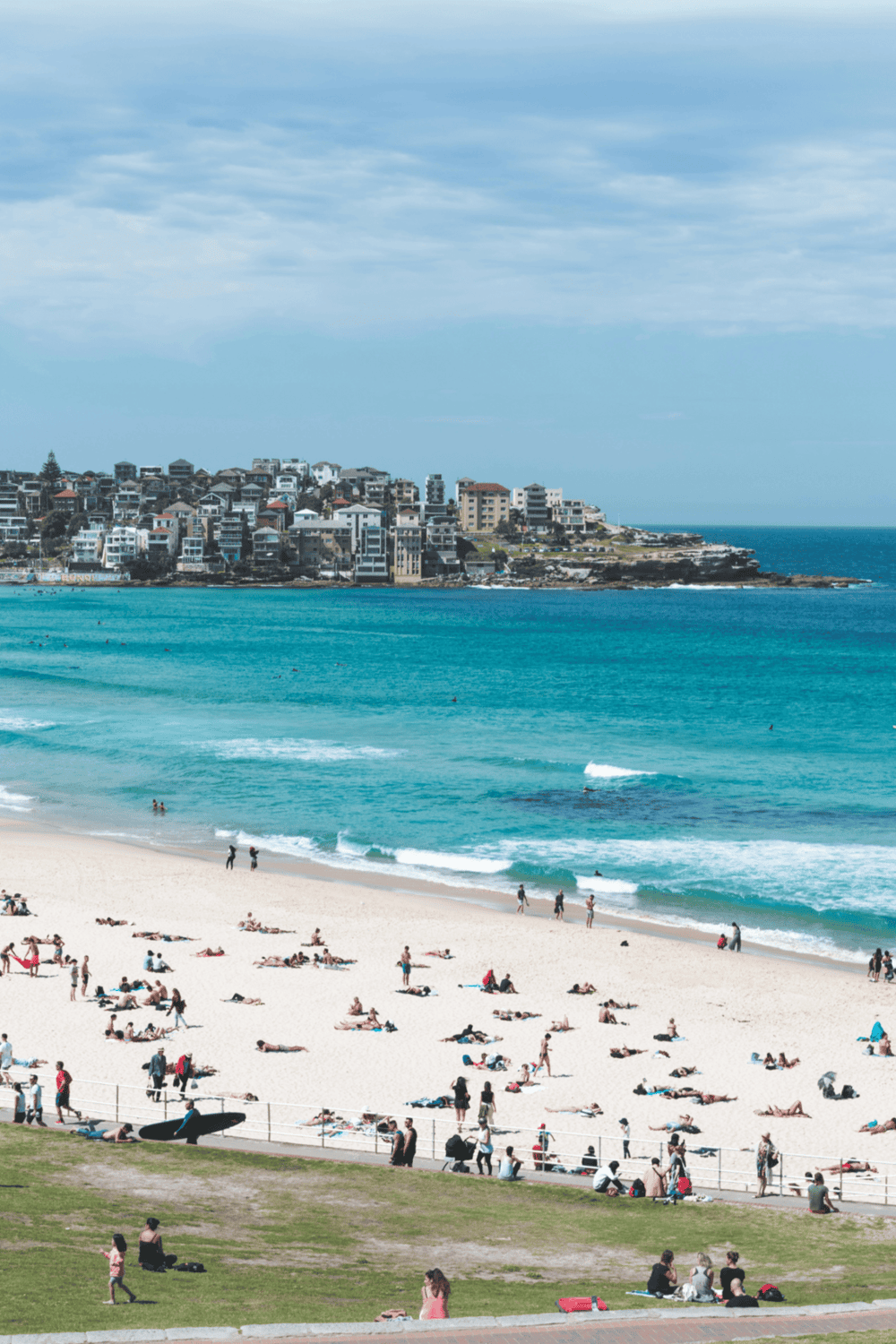 Sunset Beach in Sydney with beachgoers, surfing, and ocean view, ideal for travel and vacation destinations.