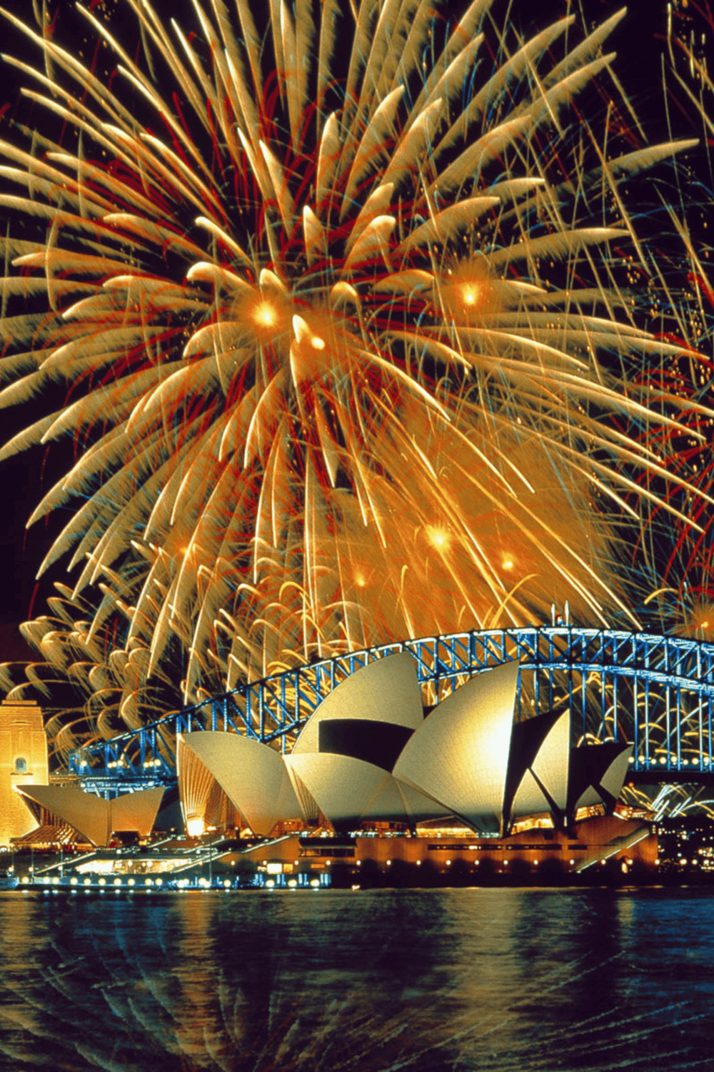 Vibrant fireworks display over Sydney Opera House and Harbour Bridge, celebrating with colorful night sky.