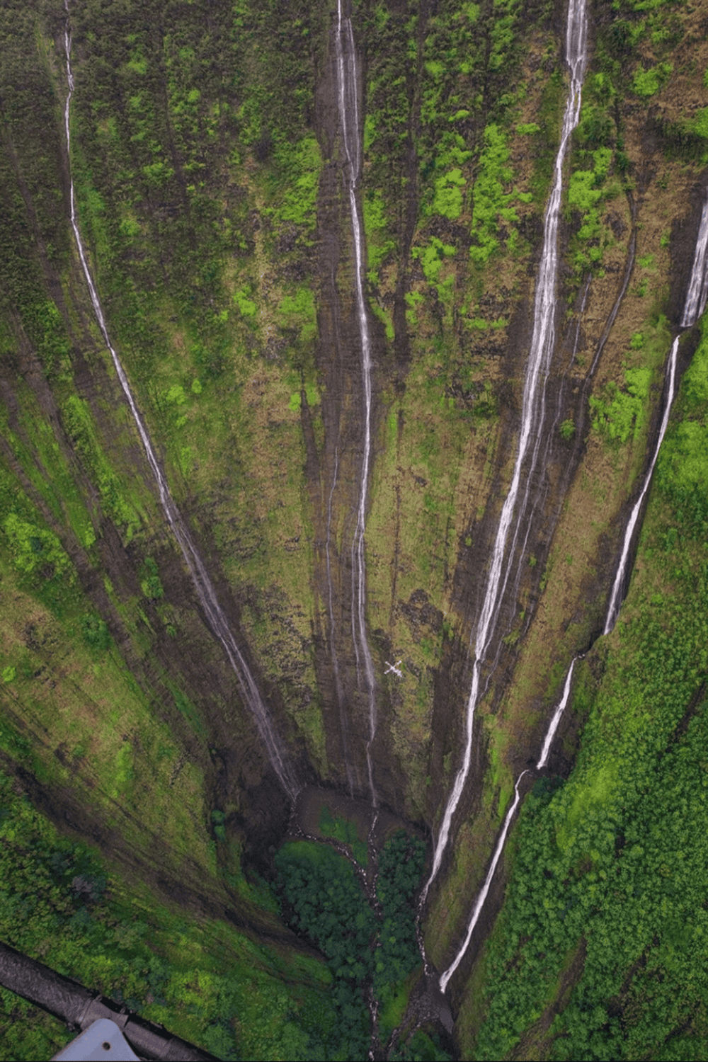 1. Waterfalls on a lush green cliffside with narrow streams cascading down.