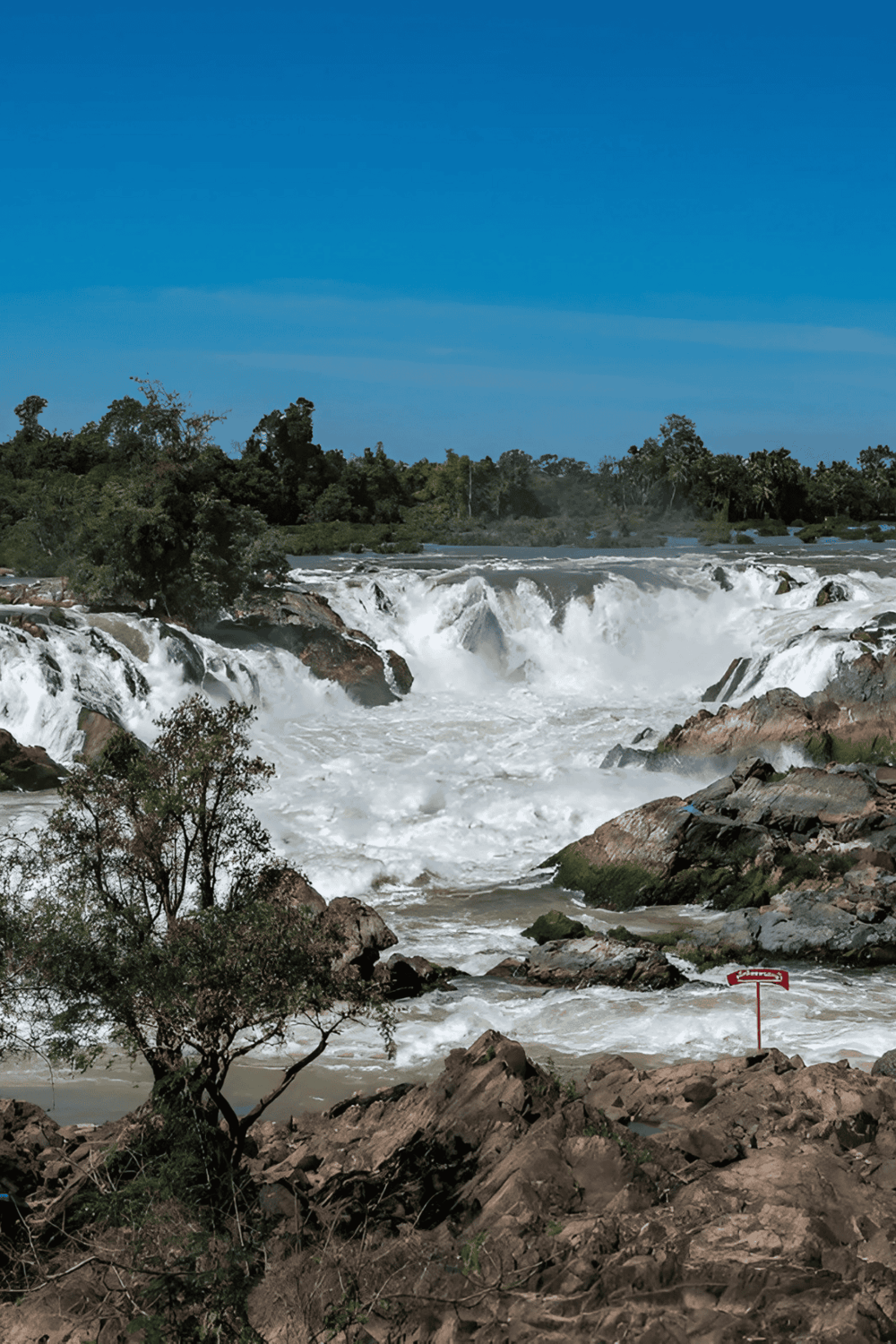 Vivid waterfall scene with rushing water and lush greenery, showcasing adventure travel destinations.