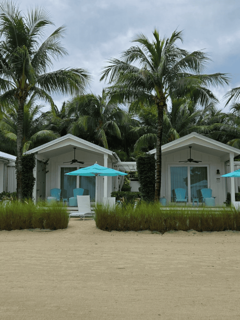 Beachside cottages with palm trees and outdoor seating at QuestForDirections resort.