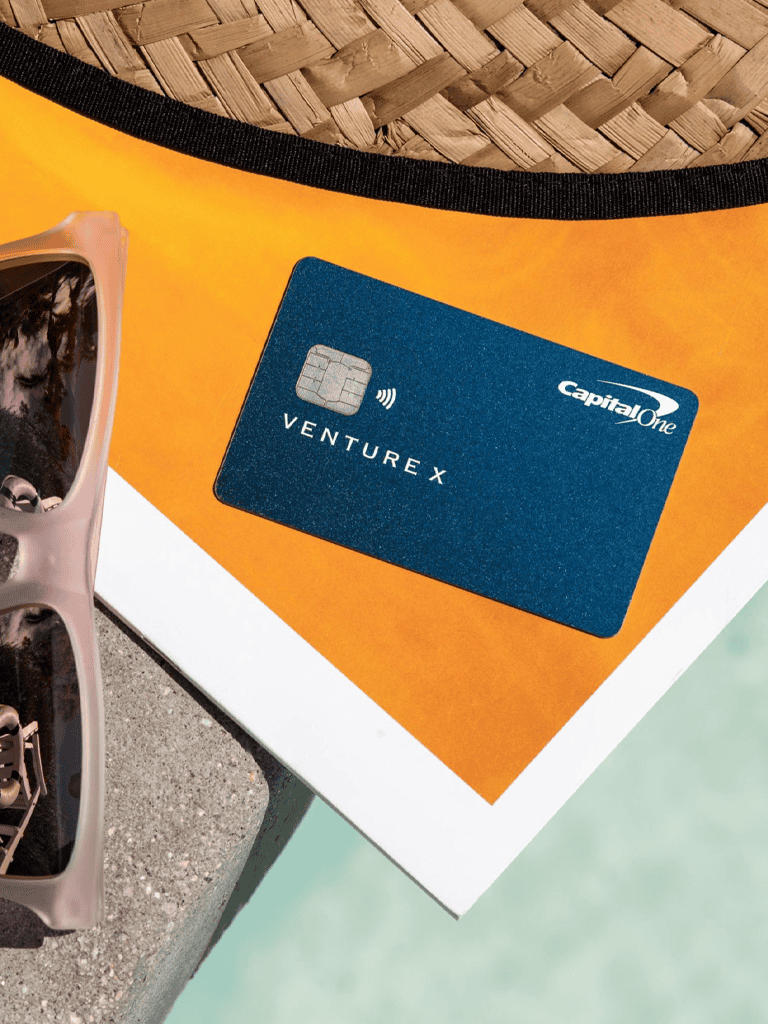 Credit card for Venture X on a colorful background, travel essentials, and summer accessories.