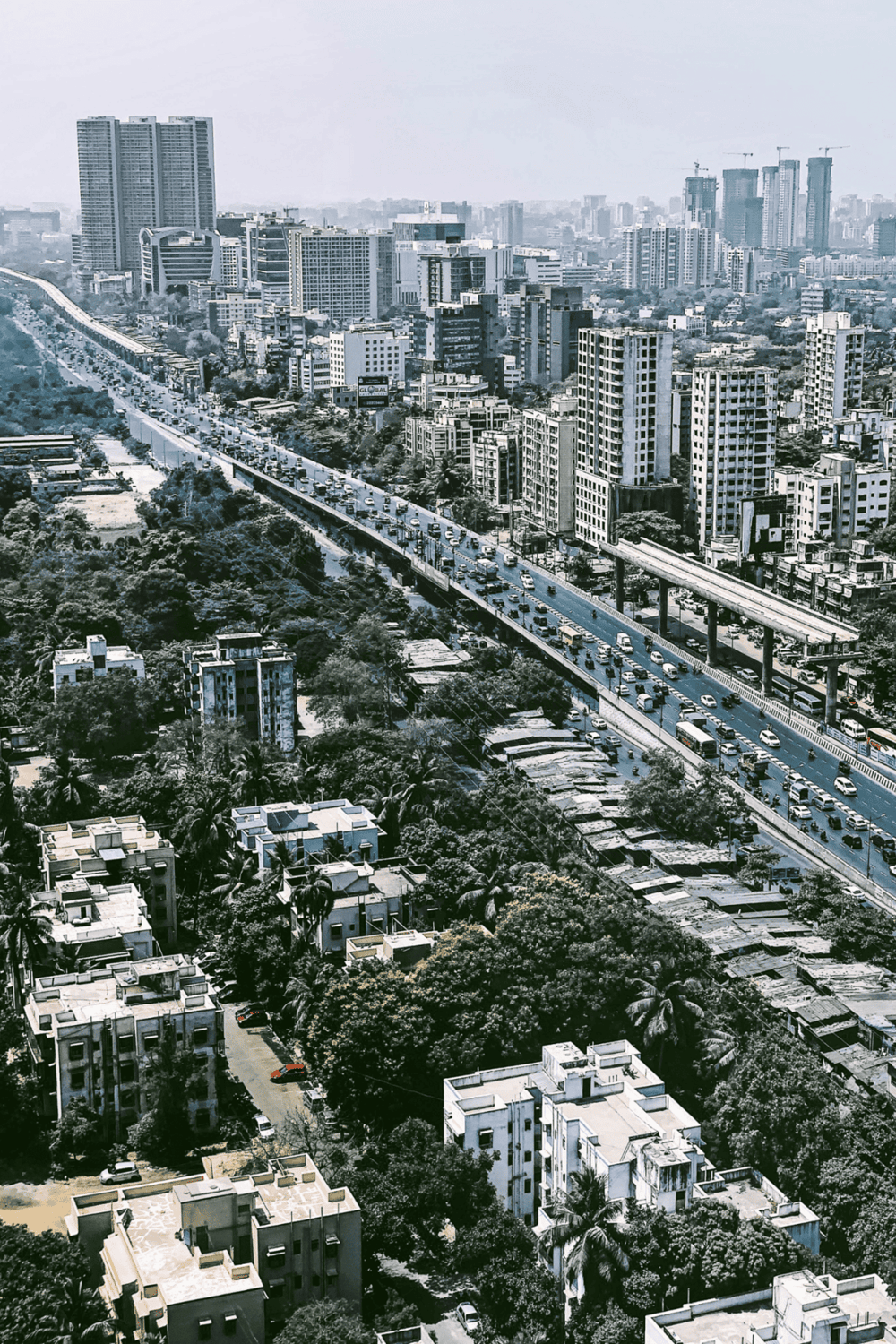 Bright city skyline with high-rise buildings and busy highway traffic in an urban landscape.