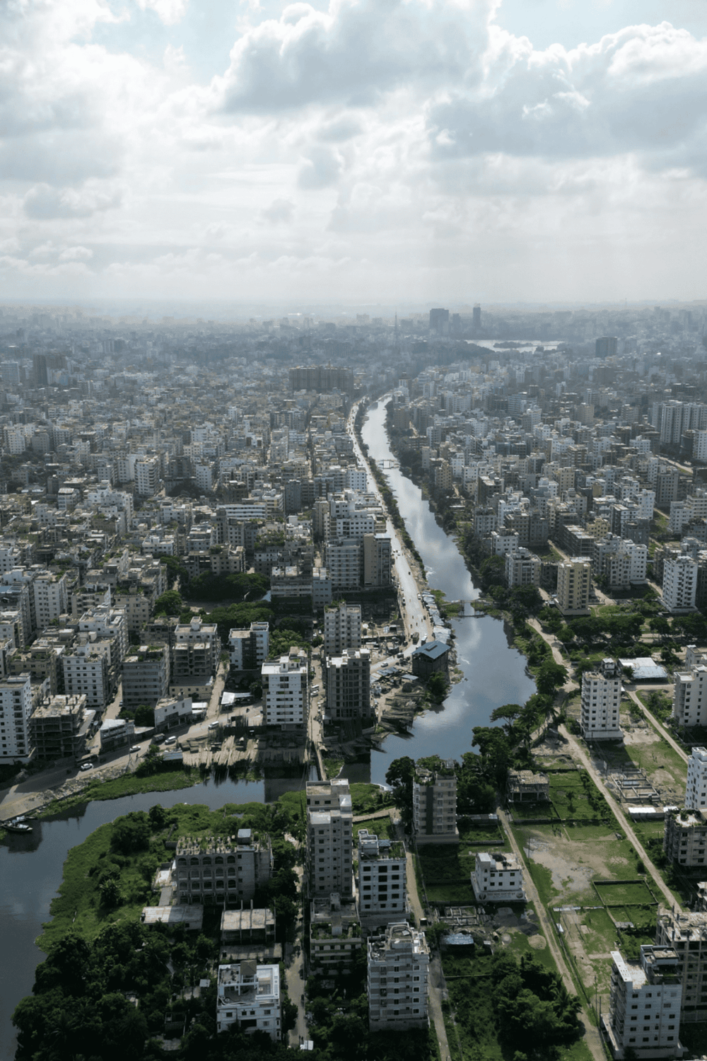 Aerial view of a bustling urban city with a winding river and high-rise buildings in the background.