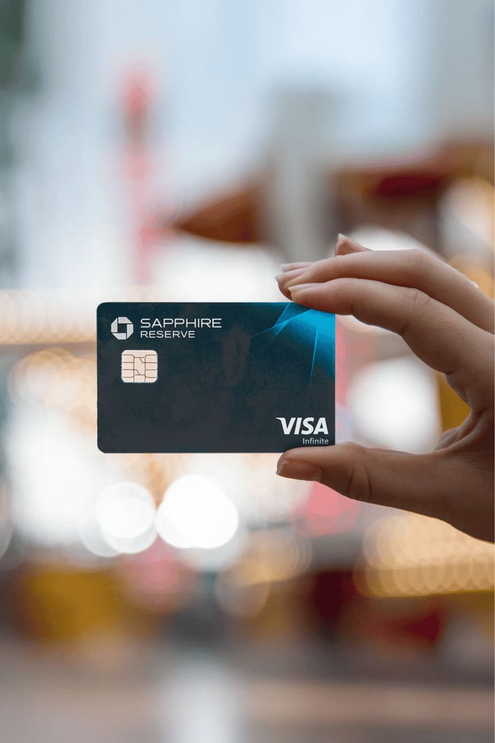 Premium Visa card held by a person in a bright, modern shopping environment.