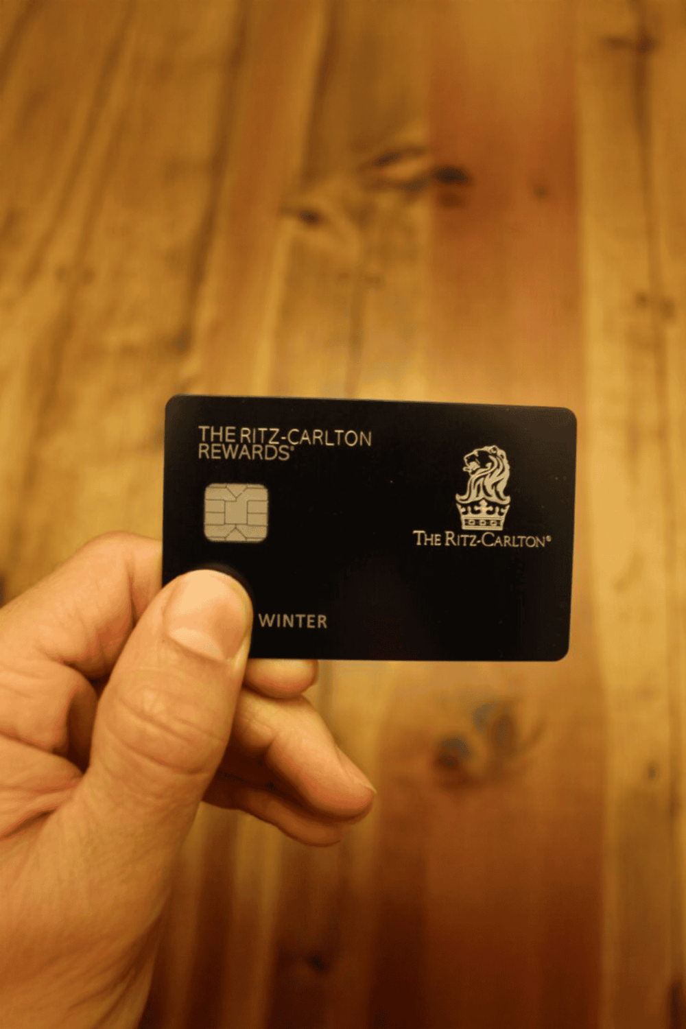 Black Ritz-Carlton Rewards membership card with winter theme and lion logo.
