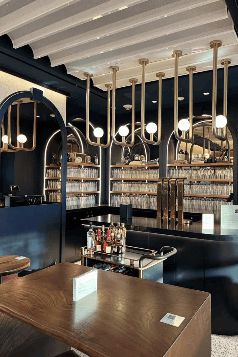 Luxury bar interior with modern decor, stylish lighting, and organized bottle display.