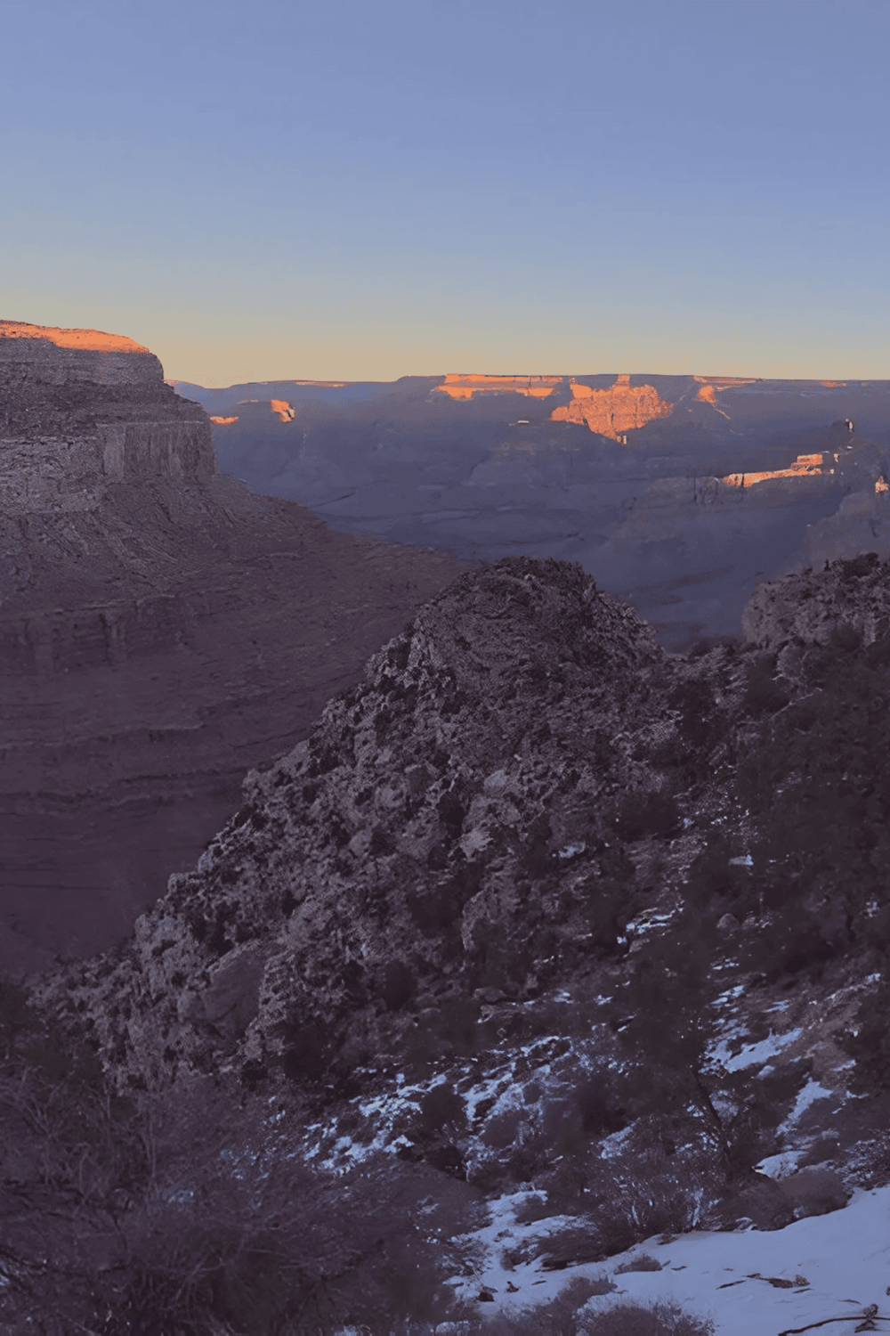 Grand Canyon scenic view during sunset, showcasing layered rock formations and vast wilderness.