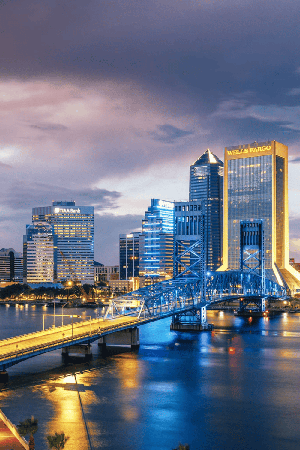 Vibrant city skyline of downtown Jacksonville, Florida with illuminated skyscrapers and bridge at dusk for travel and navigation.