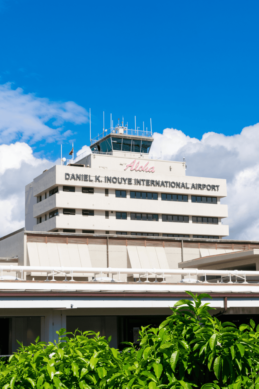 1. Honolulu Daniel K. Inouye International Airport building under blue sky with greenery.
