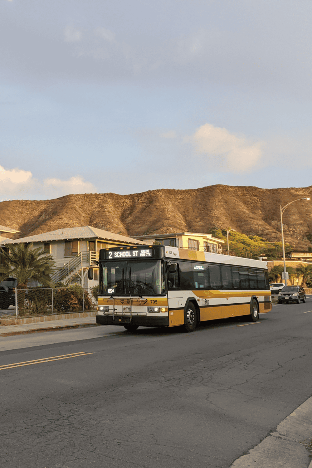 Bus transportation on city street with mountains in background.